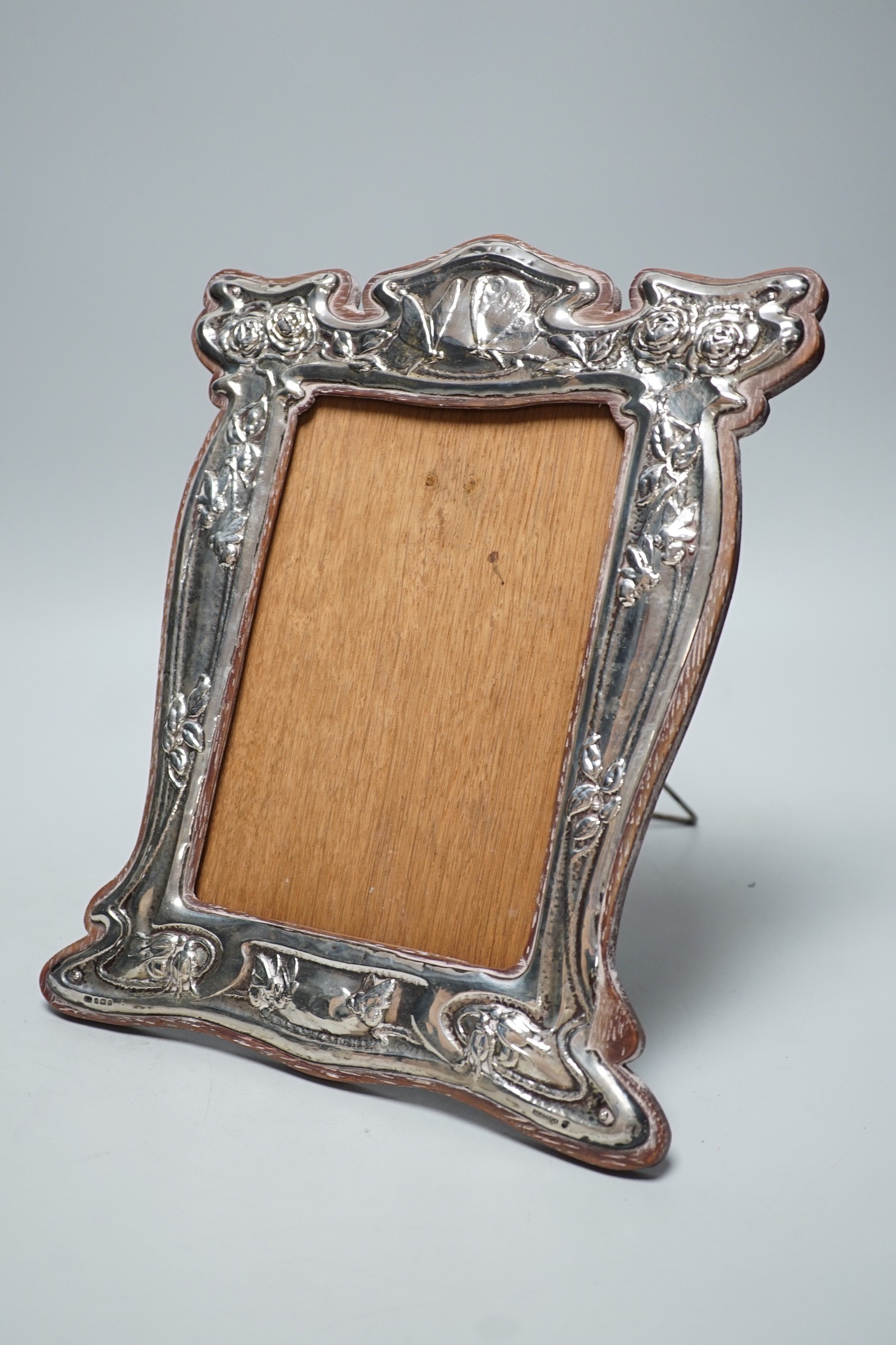 An Edwardian Art Nouveau repousse silver mounted photograph frame, decorated with insects amongst foliage, J. Aitken & Son, Birmingham, 1904, 29.9cm.